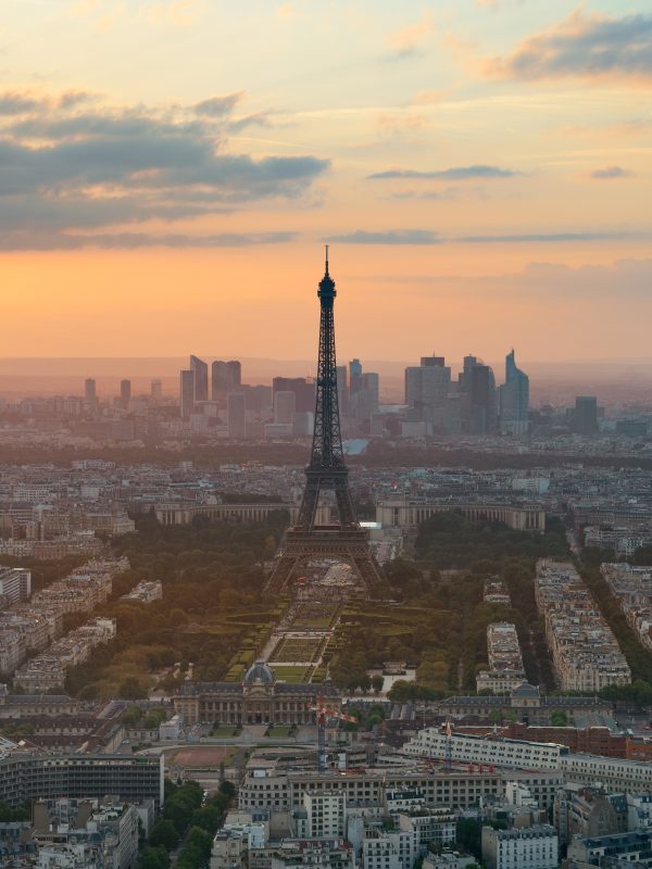 Paris city rooftop view with Eiffel Tower at sunset.